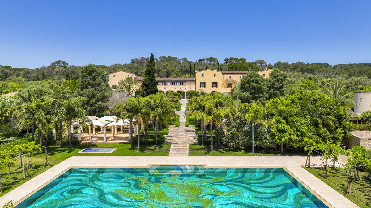 Mosaic pool and steps lined with palms leading to the Main House